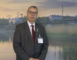 Ville Itälä står framför en tavla med landskapsmotiv